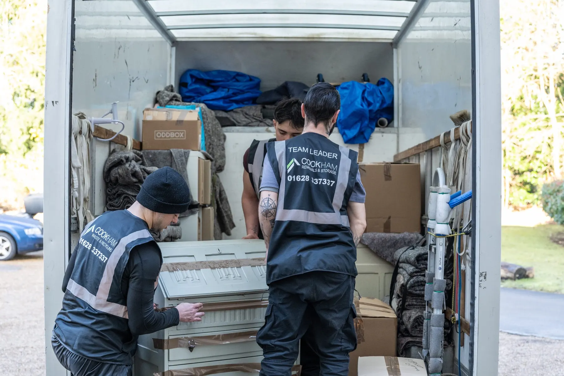 Cookham Removals & Storage crew stacking boxes and wrapped items inside the Luton van, seen from the rear doors
