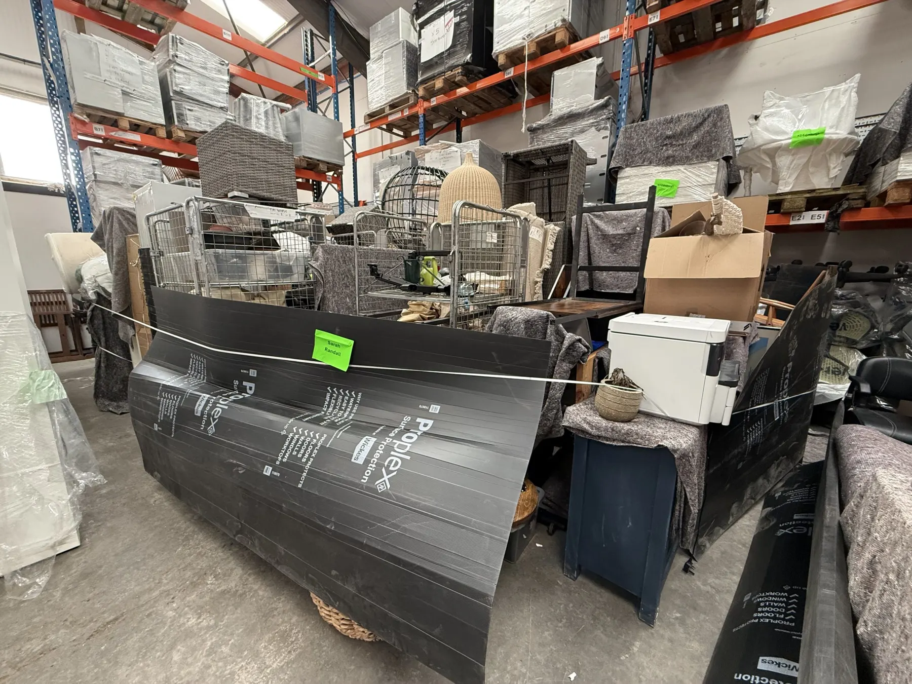 Pallet racking in the Cookham Removals & Storage warehouse holding stacked boxes and wrapped furniture