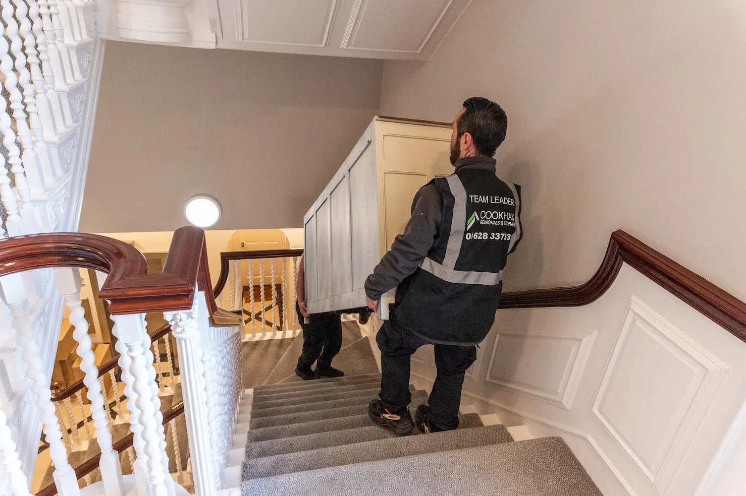 A Cookham Removals & Storage crew member carefully carrying an item down a staircase