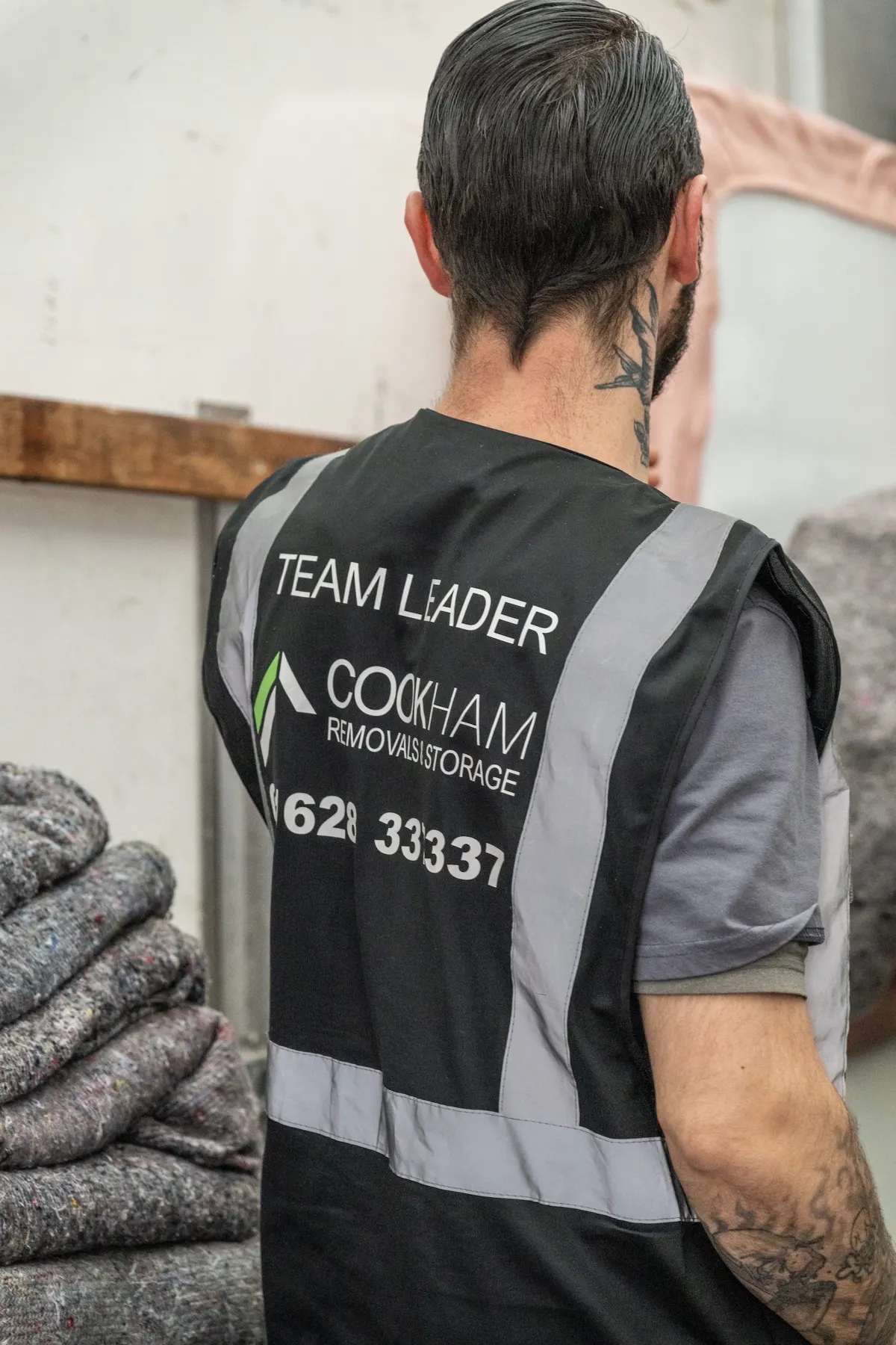 The back of a grey Cookham Removals & Storage vest marked Team Leader with the company logo
