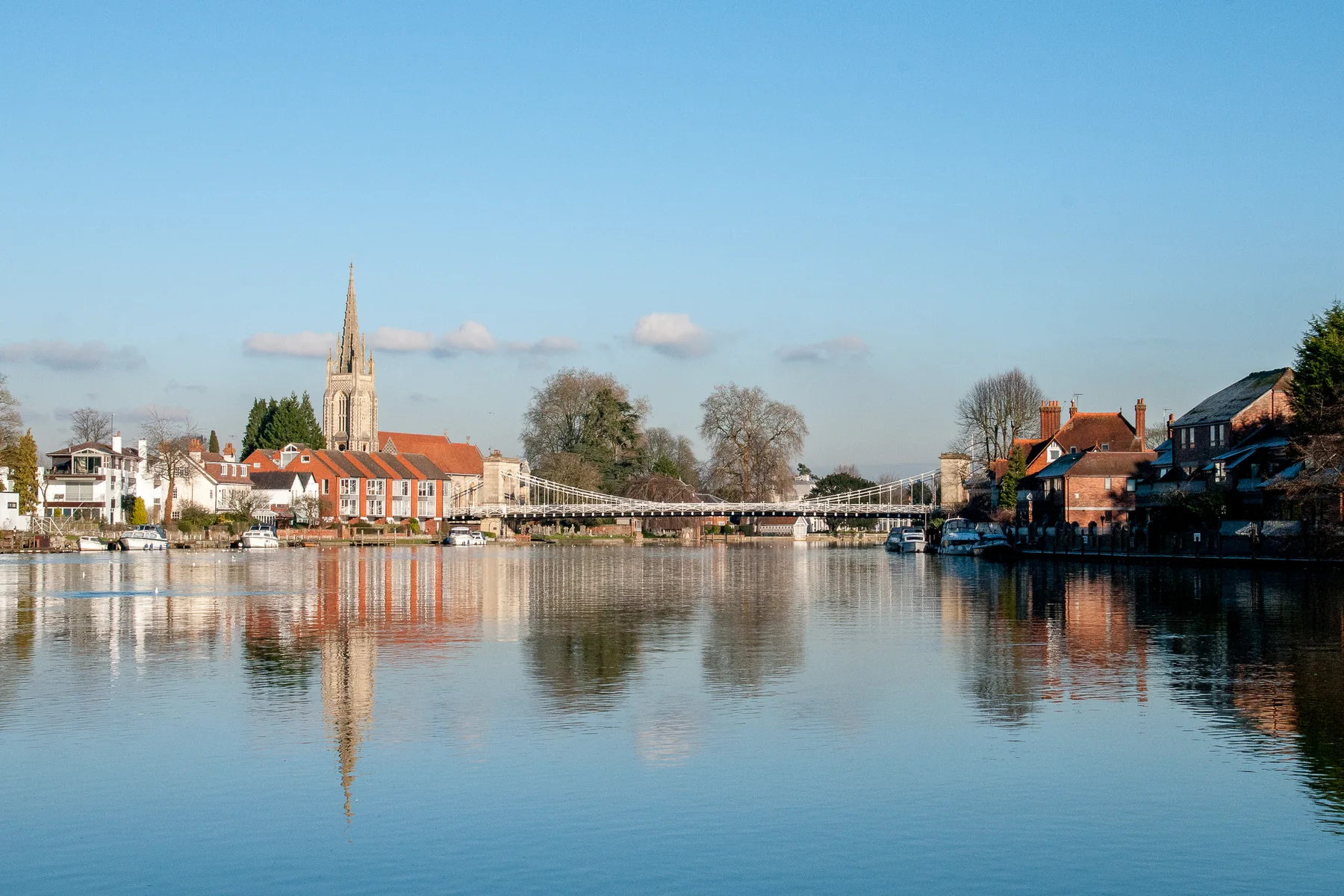 Marlow suspension bridge and the spire of All Saints church reflected in the River Thames